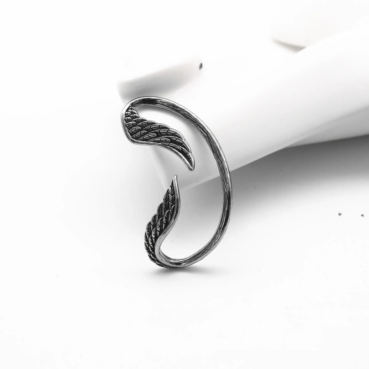 Fallen Angel Wing Ear Cuff, single silver-tone cuff on a white background