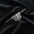 Silver moth pin on black velvet