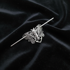 Silver moth pin on black velvet