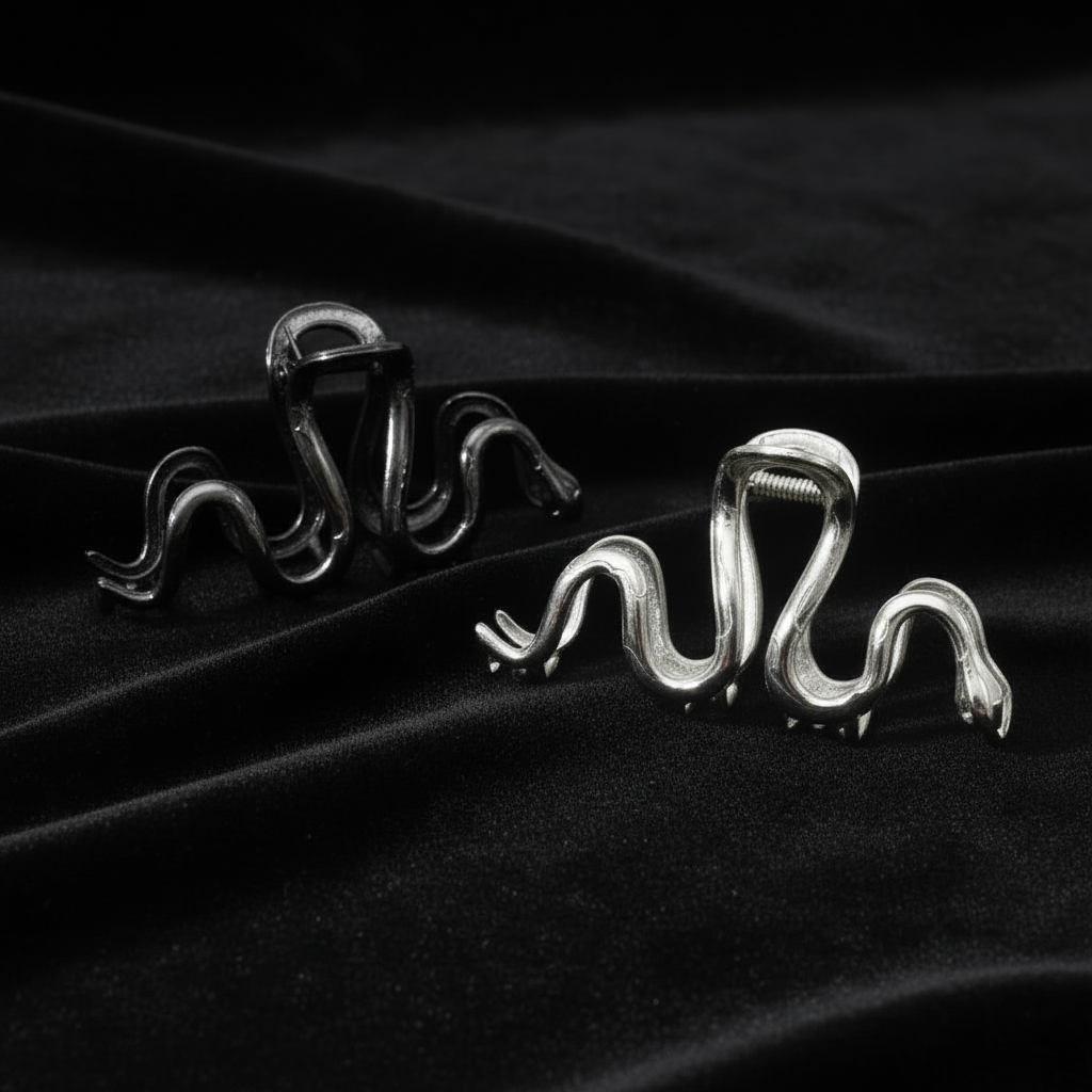 Two serpent clips gunmetal shinier and silver on black velvet