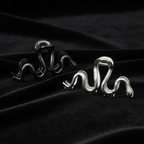 Two serpent clips gunmetal shinier and silver on black velvet